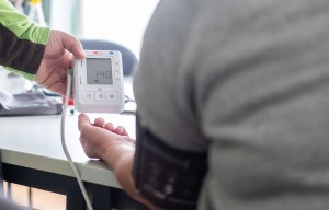 Examinierte Pflegekraft misst Blutdruck und Herzschlag